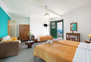 a hotel room with two beds and a couch at Akteon Rooms in Agia Galini