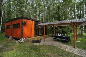 uma cabana na floresta com um gazebo em Atpūtas komplekss Lilaste em Lilaste