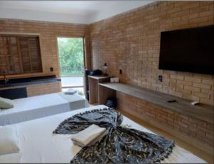 a bedroom with two beds and a flat screen tv at Parque Hotel Holambra in Holambra