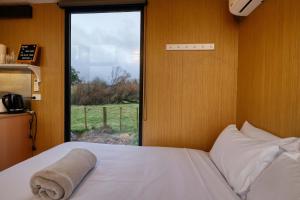 a bedroom with a bed and a window with a view at Wahi Marie X by Tiny Away in Puketitiri