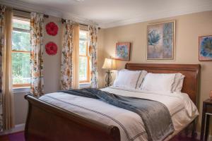 a bedroom with a large bed and two windows at National Harbor Guesthouse in Fort Washington