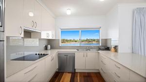 a white kitchen with a sink and a window at Quayside in Nambucca Heads