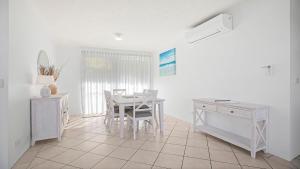 a dining room with a table and a desk at Quayside in Nambucca Heads +10 photos