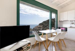 a kitchen with a large window and a table and chairs at Akteon Rooms in Agia Galini