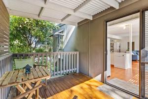 a balcony with a wooden table and a dining table at The Treehouse at Long Beach in Long Beach