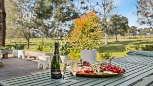 a table with a plate of food and a bottle of wine at Hunter Grange - The Vintage in Pokolbin +11 photos