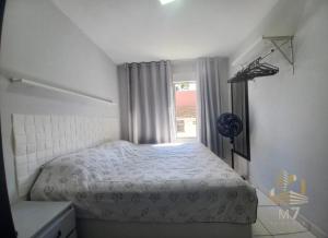 a small bedroom with a bed and a window at Loft Ponta Aguda in Blumenau