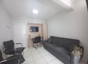 a living room with a couch and a table and chairs at Loft Ponta Aguda in Blumenau
