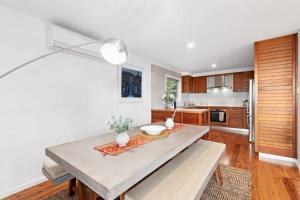 a kitchen with a dining table and a kitchen with wooden cabinets at Long Beach Hideaway in Long Beach