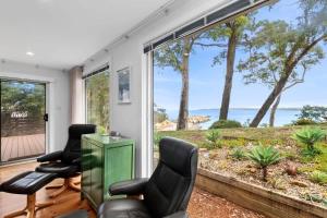 a living room with chairs and a view of the ocean at Long Beach Hideaway in Long Beach