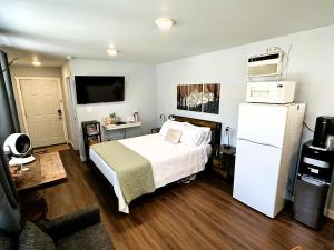 a bedroom with a white bed and a refrigerator at The Hut at Deer Hollow in Three Rivers +12 photos