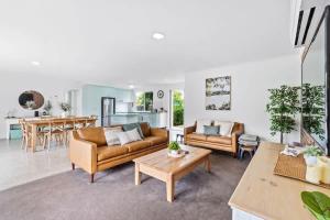 a living room with two couches and a table at Light and Bright at Maloneys in Maloney's Beach