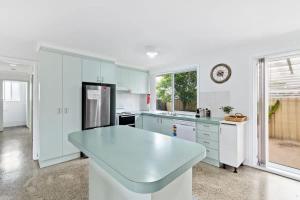 a kitchen with white cabinets and a white counter top at Light and Bright at Maloneys in Maloney's Beach