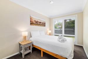 a bedroom with a bed and a window at Light and Bright at Maloneys in Maloney's Beach +7 photos