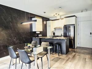 a kitchen with a table and chairs and a counter at Le201 Condo Chic Free Parking in Quebec City