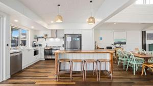 a kitchen with a counter and a table with chairs at 19 Newry St in Nambucca Heads