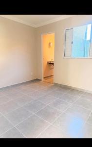 an empty room with a tile floor and a window at Casa Centro in Paulínia
