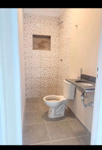 a bathroom with a toilet and a sink at Casa Centro in Paulínia