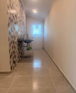 an empty hallway with a tile floor and a window at Casa Centro in Paulínia
