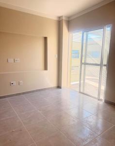 an empty room with a large sliding glass door at Casa Centro in Paulínia