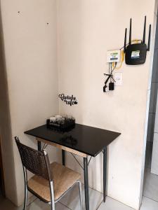 a black table with two chairs and a tv on a wall at Kitnet Completa Próx Unipampa e Centro Wi-Fi in Alegrete +2 photos