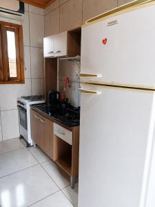 a kitchen with a refrigerator and a stove at Kitnet Completa Próx Unipampa e Centro Wi-Fi in Alegrete