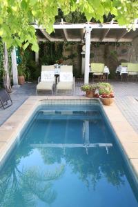 Franschhoek的住宿－威利之心旅館，庭院内的游泳池,配有桌椅