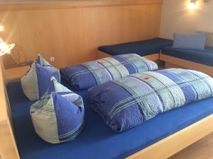 two beds on a boat with blue pillows at Ferienwohnungen Marchanger in Niederau