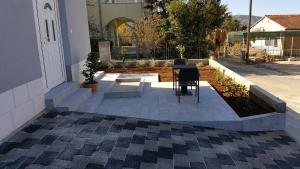 a patio with a table and chairs in a yard at Apartments Parcela in Seget Vranjica