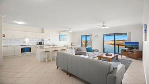 a large living room with a couch and a kitchen at Mountains By The Sea in Nambucca Heads