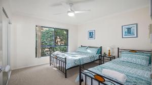 a bedroom with two beds and a window at Mountains By The Sea in Nambucca Heads