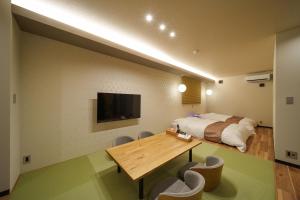 a bedroom with a bed and a table and chairs at 別府の宿 結 -Yui- in Beppu