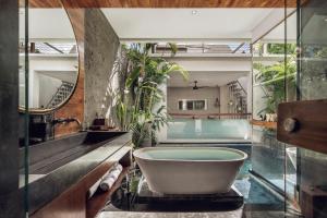 a bathroom with a bath tub and a sink at Ayona Villa Seminyak by Ini Vie Hospitality in Seminyak +31 photos