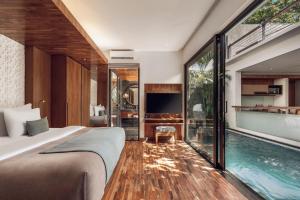 a bedroom with a bed and a swimming pool at Ayona Villa Seminyak by Ini Vie Hospitality in Seminyak