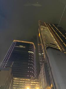 two tall buildings are lit up at night at apart iconmall SL in Singopadu