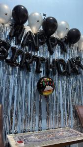 a bunch of balloons are hanging over a fence at apart iconmall SL in Singopadu