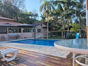a pool with a table and chairs on a wooden deck at Recanto dos Passaros in Socorro