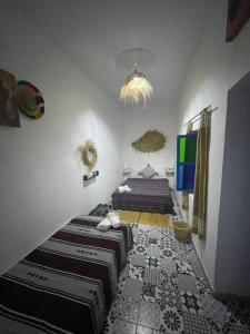 a bedroom with two beds and a chandelier at Riad hotel borj in Tétouan