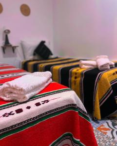 a room with three beds with colorful blankets at Riad hotel borj in Tétouan