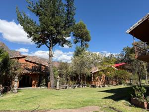 a yard with a tree and a house at La Quinta Eco Hotel in Urubamba