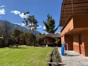 a person standing in a yard next to a house at La Quinta Eco Hotel in Urubamba
