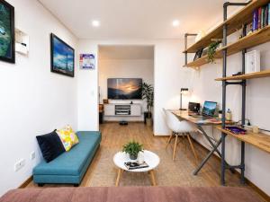 a living room with a blue couch and a desk at Edificio Urban in Cajicá