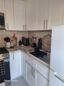 a kitchen with white cabinets and a stove top oven at Beautiful studio in Azusa