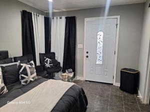 a bedroom with a bed and a chair and a door at Beautiful studio in Azusa
