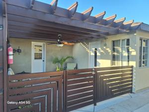 a wooden fence with a wooden pergola on a house at Beautiful studio in Azusa