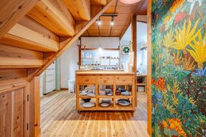 a kitchen with wooden floors and a painting on the wall at The Sticks Inatori in Higashiizu