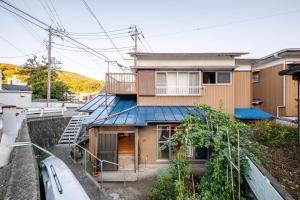 an apartment building with a blue roof at The Sticks Inatori in Higashiizu