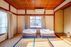 a room with two beds in front of a window at The Sticks Inatori in Higashiizu