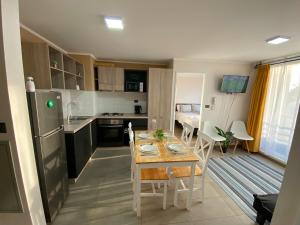 a kitchen and living room with a table and chairs at Casa Laguna Suites in Concepción