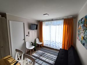 a living room with a couch and chairs and a window at Casa Laguna Suites in Concepción